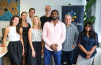 eight people smiling at the camera in an office