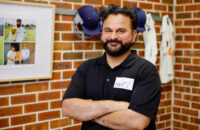 man in a sport shed smiling at camera