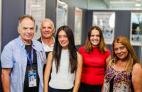 five people smiling at the camera in an office