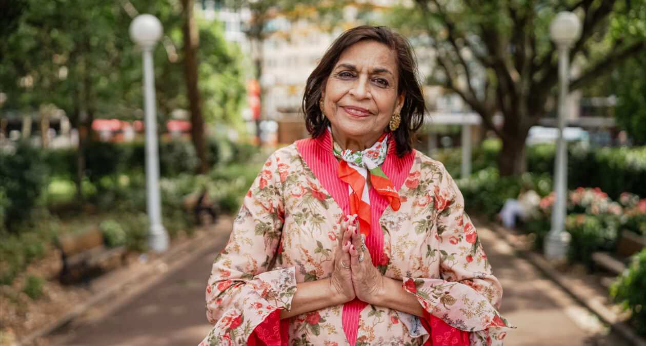 woman colourful dress with hands in prayer position