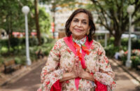 woman colourful dress with hands in prayer position