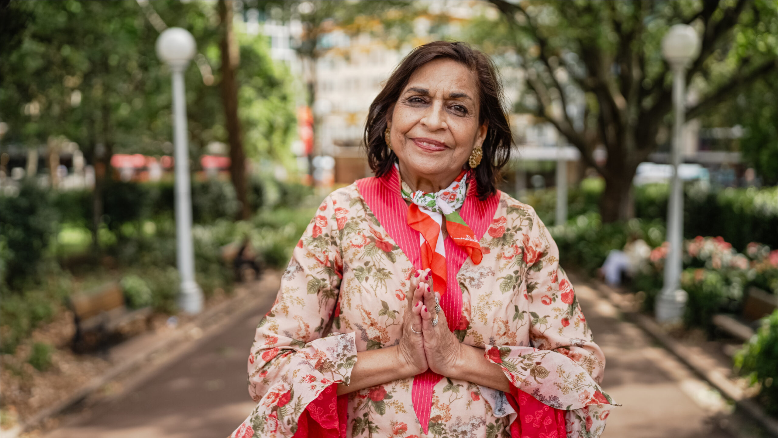 woman colourful dress with hands in prayer position
