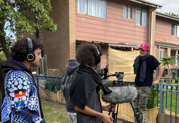 Young people outdoors with a camera doing some filming.