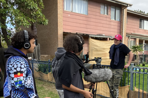 Young people outdoors with a camera doing some filming.