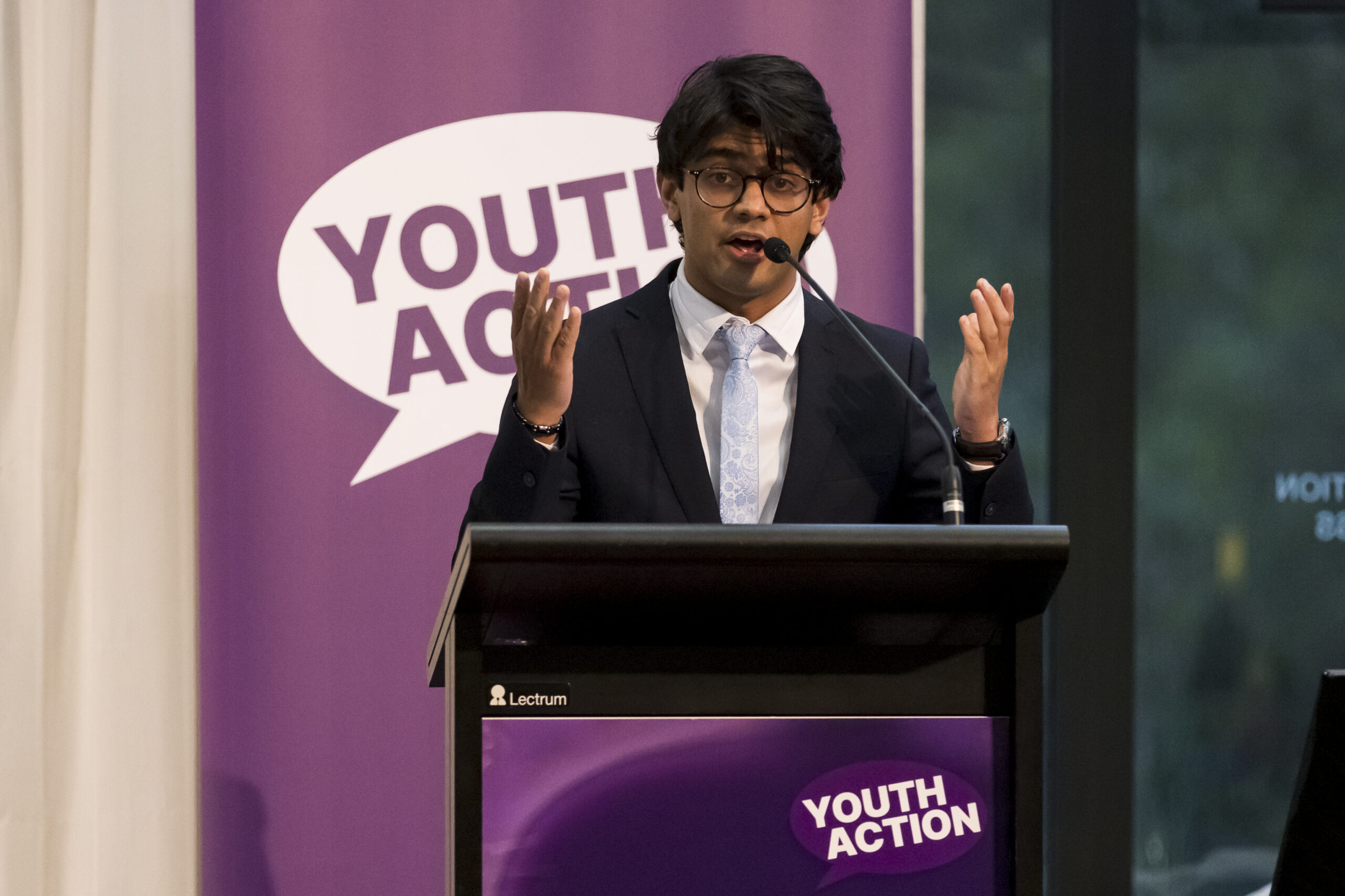 A young person speaking at a lectern.