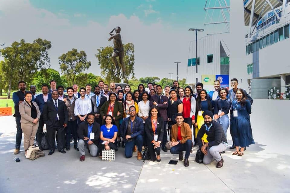 A group of people posing for a photo in front of a stadium